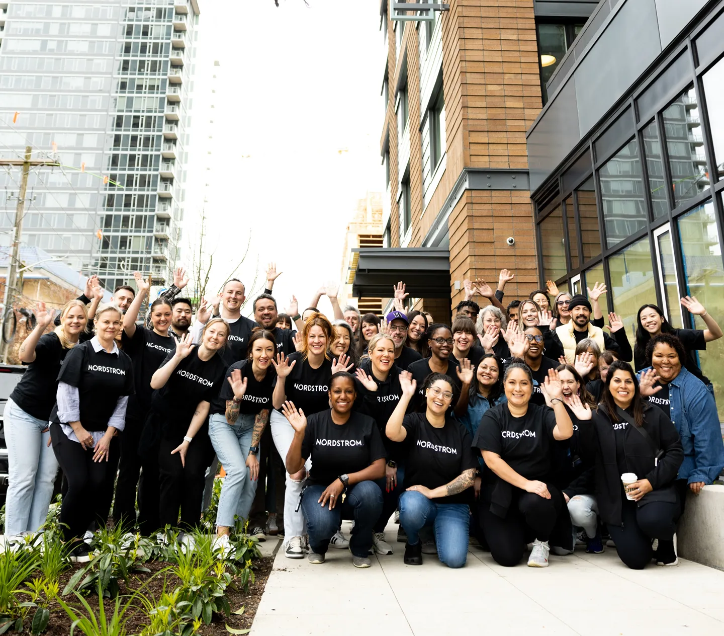 a group of people in Nordstrom black shirts posing for a photo