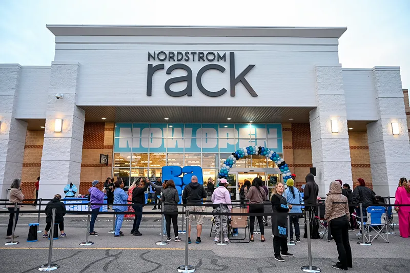 a crowd of people stand outside a Northstrorm Rack store