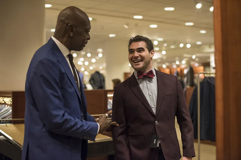 two men in suits talking in a store