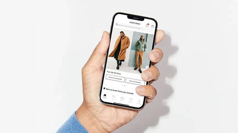 a person holding an iphone with a shopping app on it