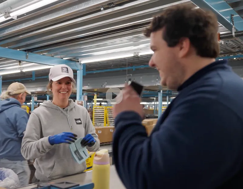 a man and woman in a factory talking to each other