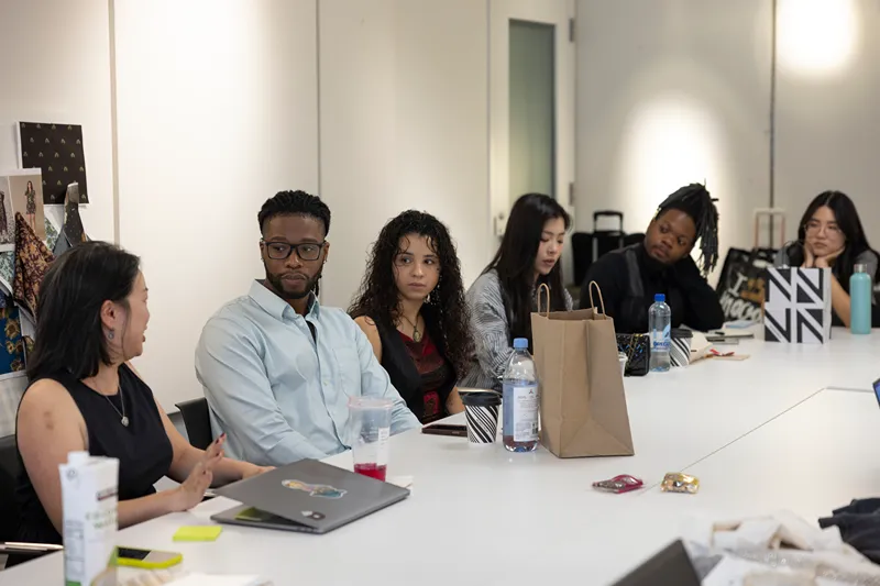 Diverse group of interns listening intently at a meeting table