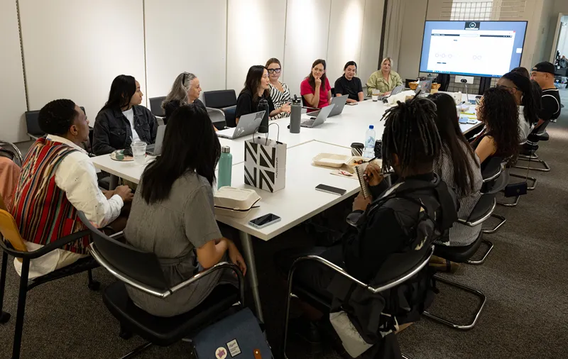a group of people sitting around a table in a conference room