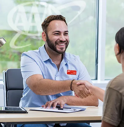 Man shaking hands with customer in Avis office setting