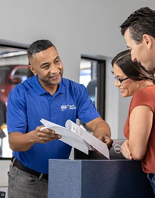 Salesperson in blue shirt assists couple with Dell product box