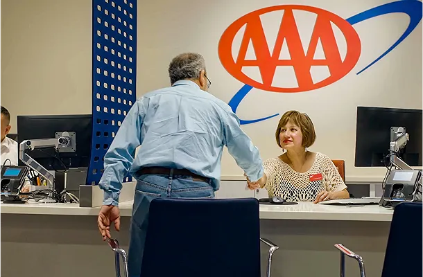 Man shaking hands with AAA representative at counter