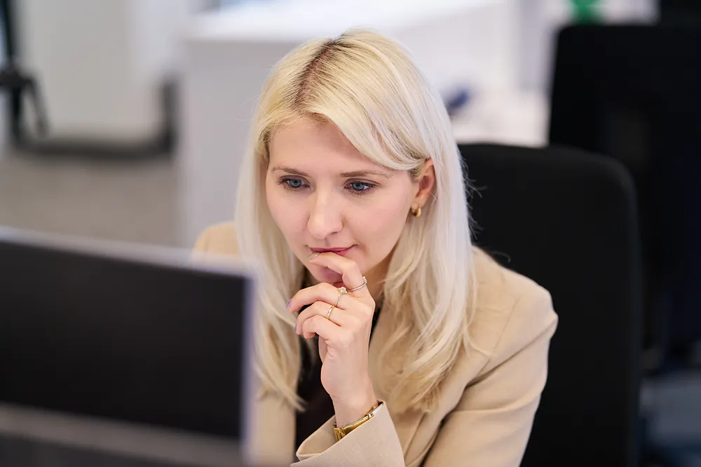 A focused corporate employee is working at her desk in a modern office