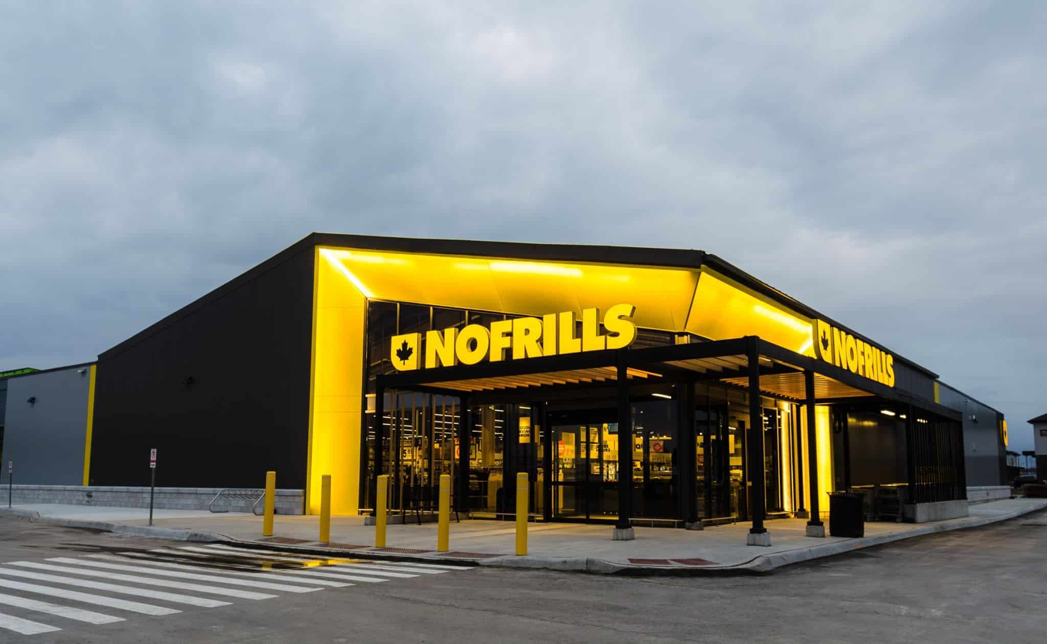 The exterior of a No&nbsp;Frills grocery store is illuminated at dusk.