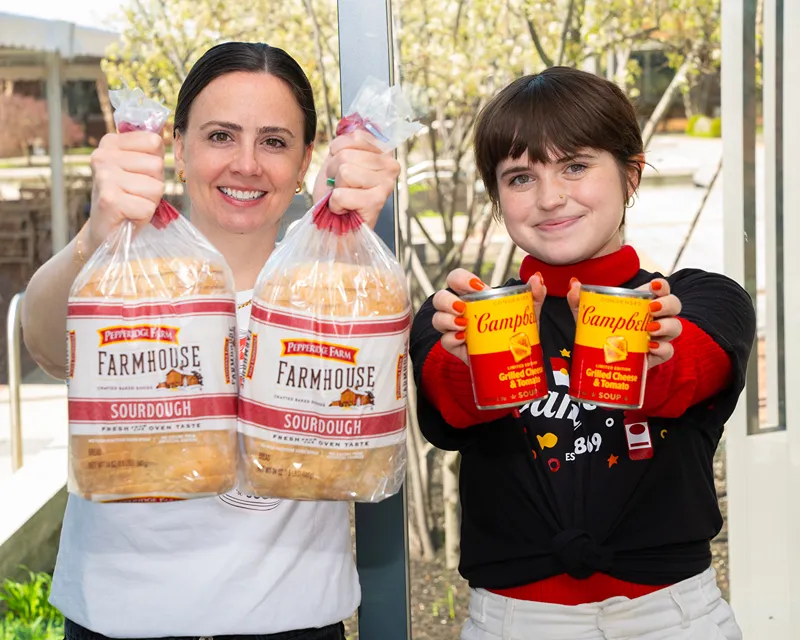 Two women holding Pepperidge Farm sourdough bread and Campbell's soup cans