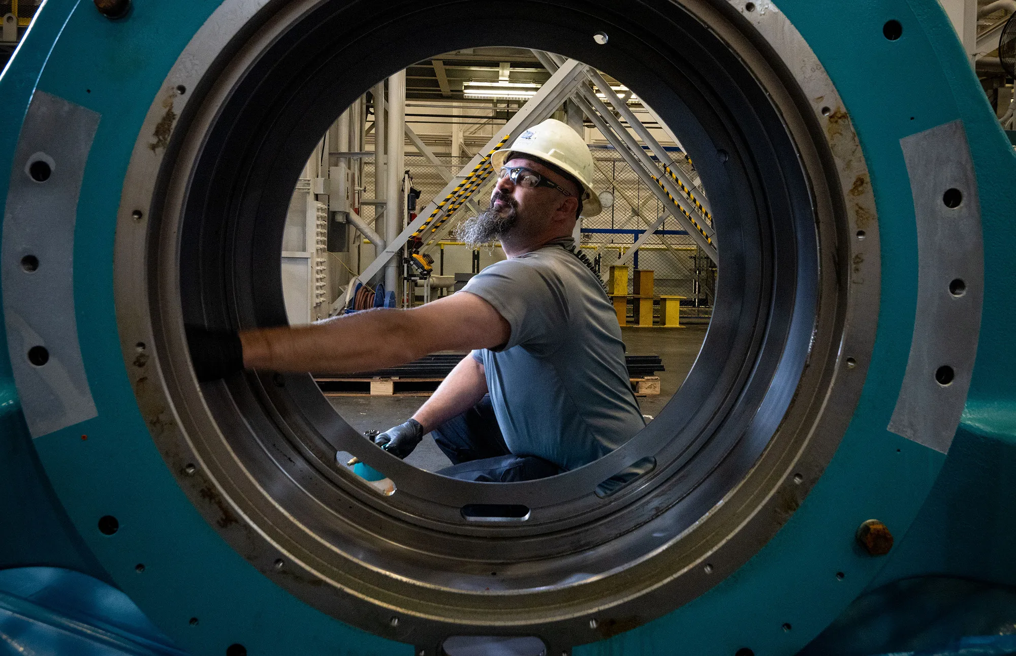 A photograph of a man taken in between a large machine