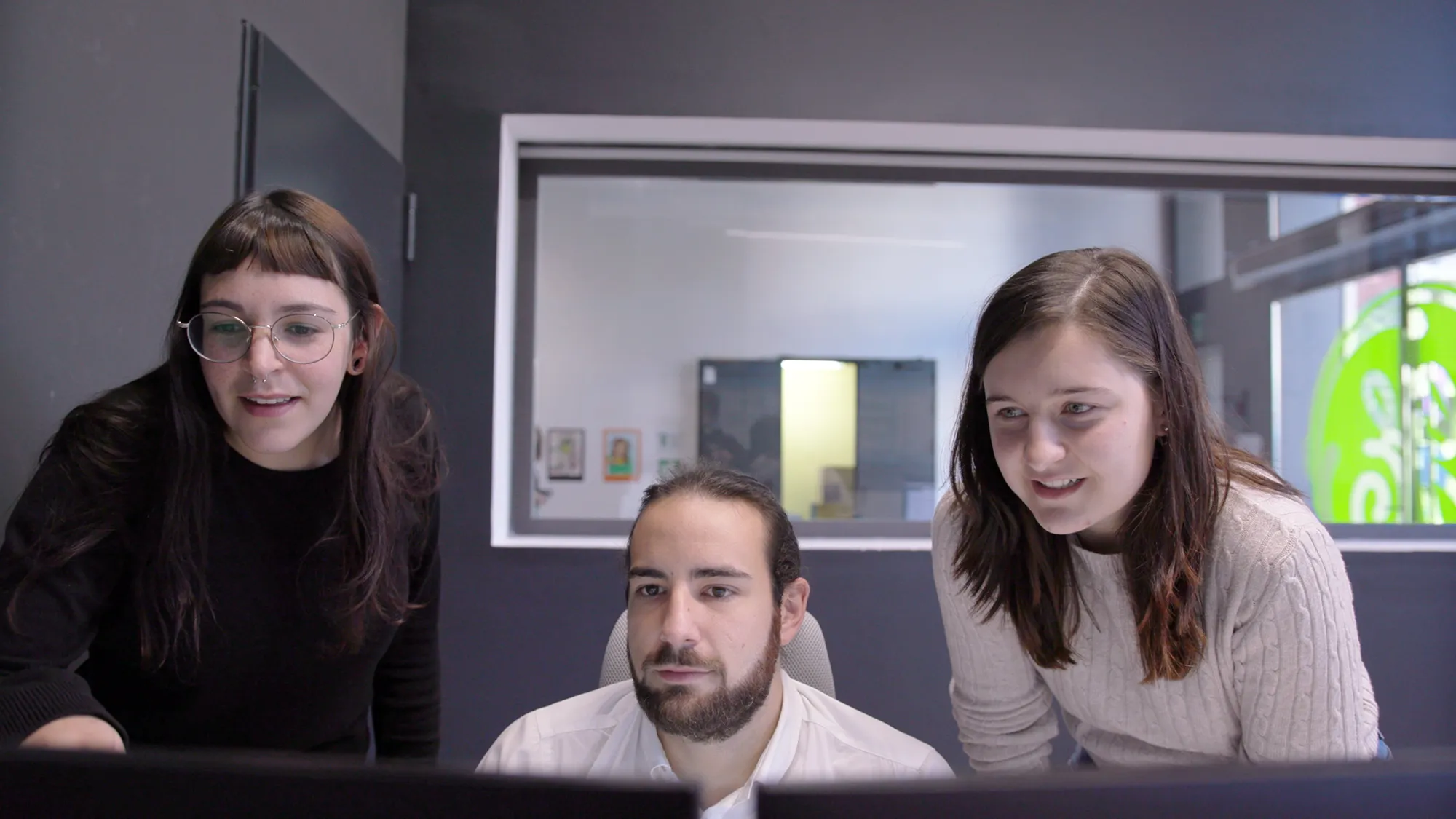 A photo of a group of people looking at a computer