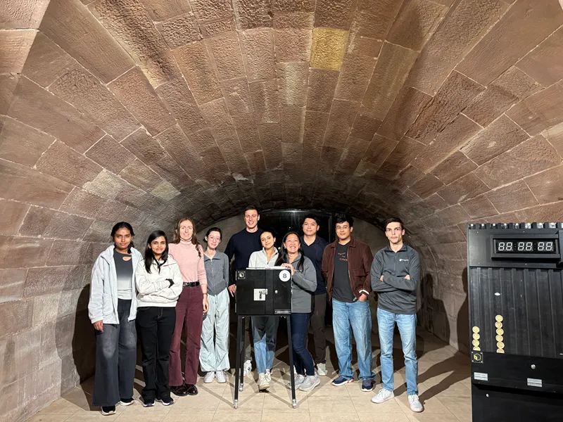 A group of people pose for a photo inside of a brick tunnel