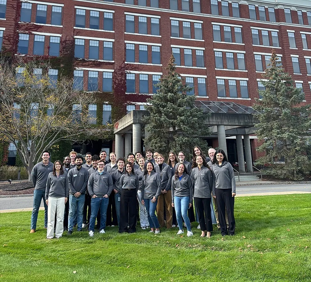 A group of people pose for a photo outside a large office building