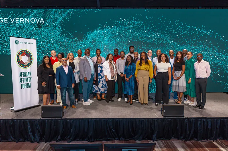 A group of people stand on stage next to a banner that reads African Affinity Forum