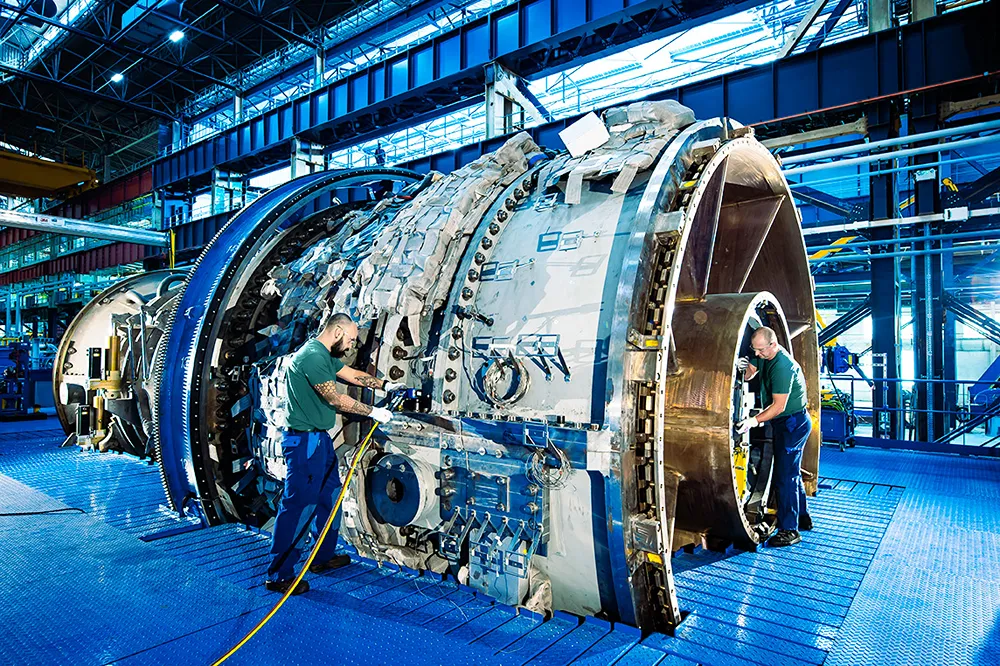 Two men work on a large piece of machinery