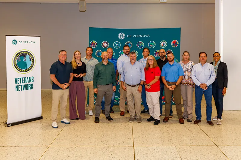 A group of people stand next to a banner that reads Venterans Network