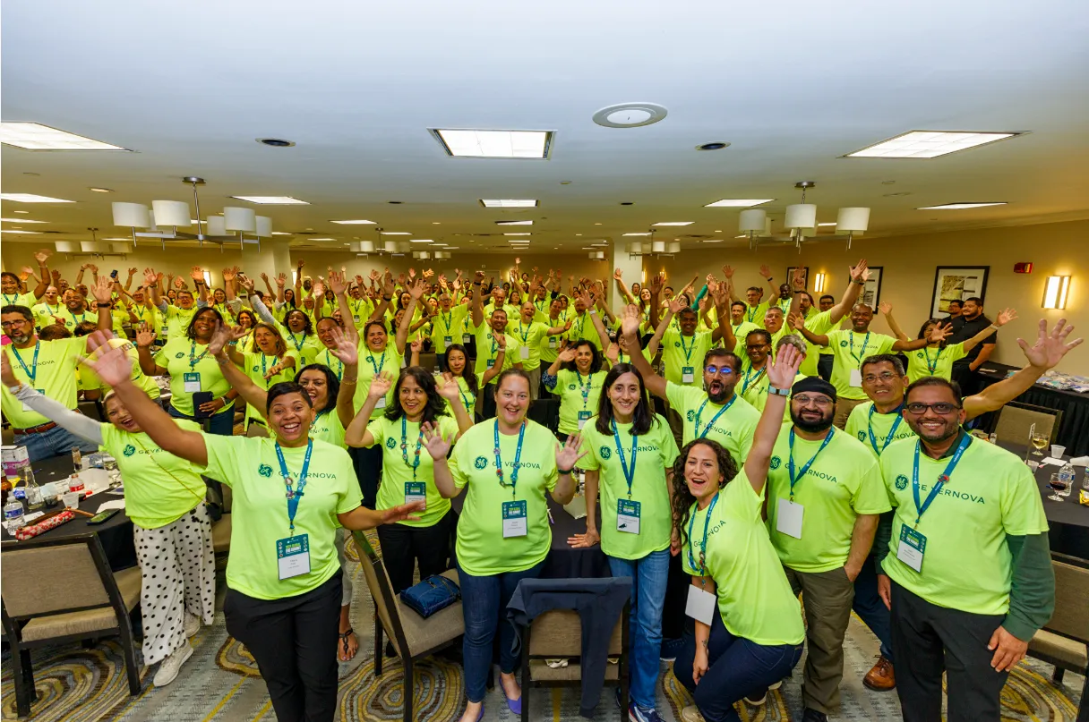 A group of employees pose for a group photo inside an office building