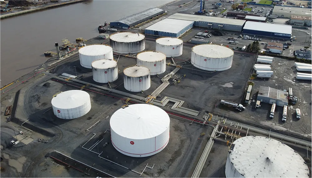 Aerial view of an industrial site with large white storage tanks and surrounding infrastructure