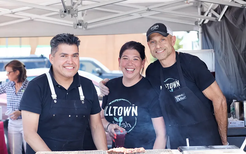 A group of three people working at a food stall