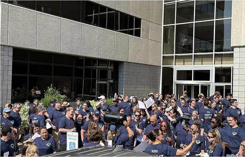 A group of people wearing matching t-shirts standing together outside