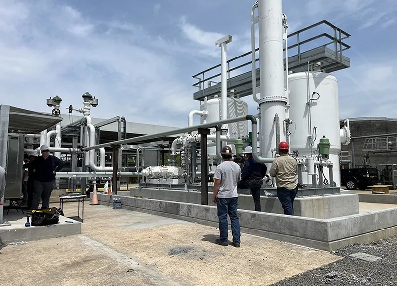A group of 3 people working on machinery