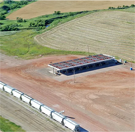 Aerial view of train cars near an industrial facility with surrounding agricultural fields