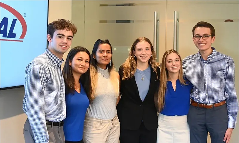 A group of people pose for a photograph in an office building