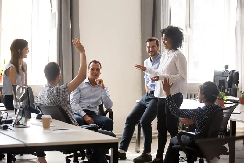 A group of six people having a discussion in a bright office