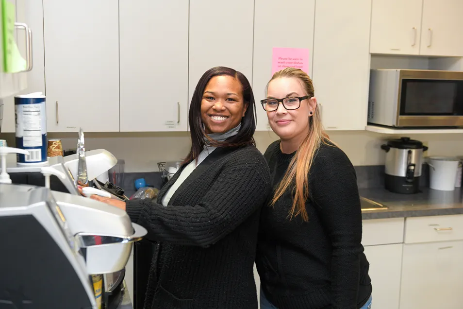 A pair of woman in an office break room