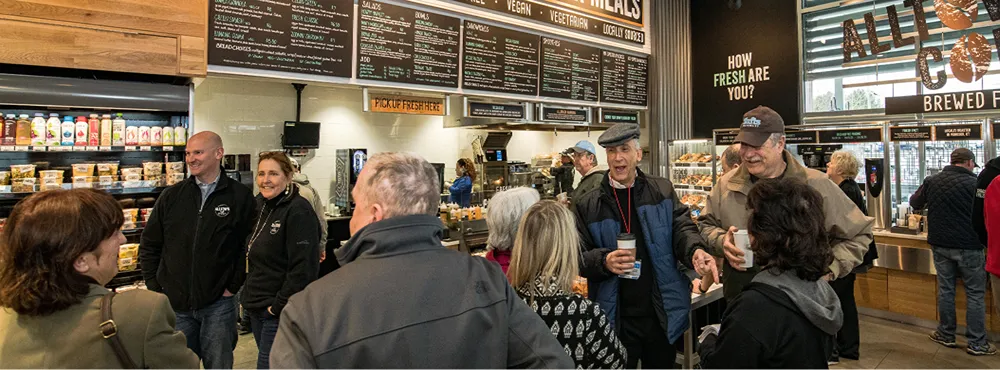 A group of people standing and talking in a grocery store