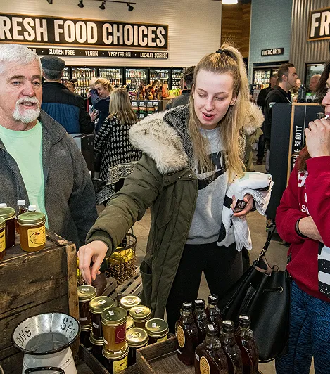 A woman in a grocery store examining a display of items
