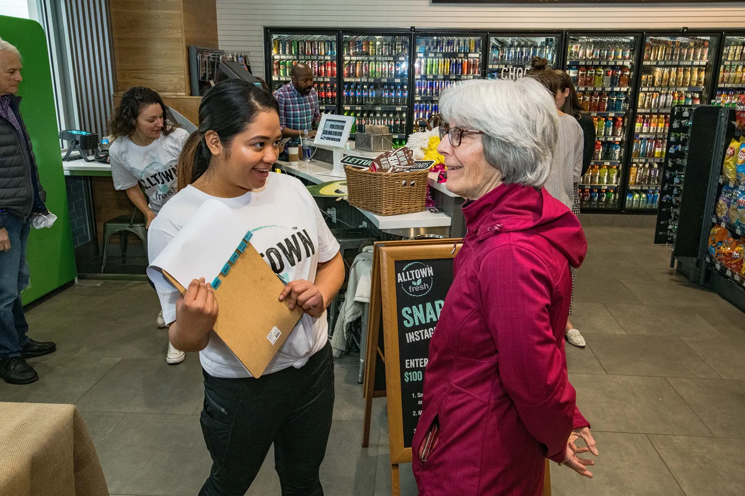 A pair of women speaking in a convience store