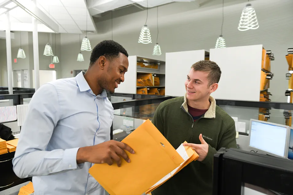 A group of men looking at a manilla envelope