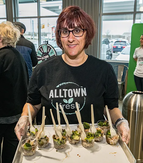 A woman holding a tray of food samples
