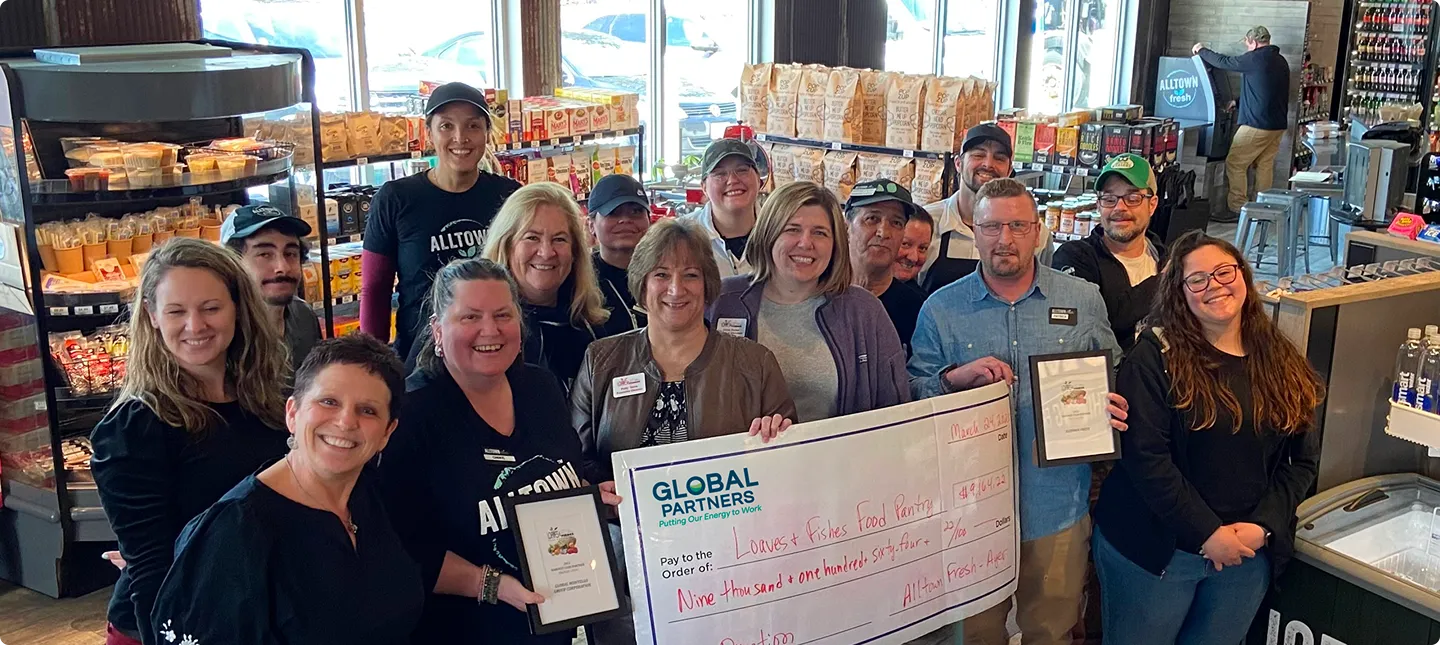 A group of people holding a large paper check in a grocery store