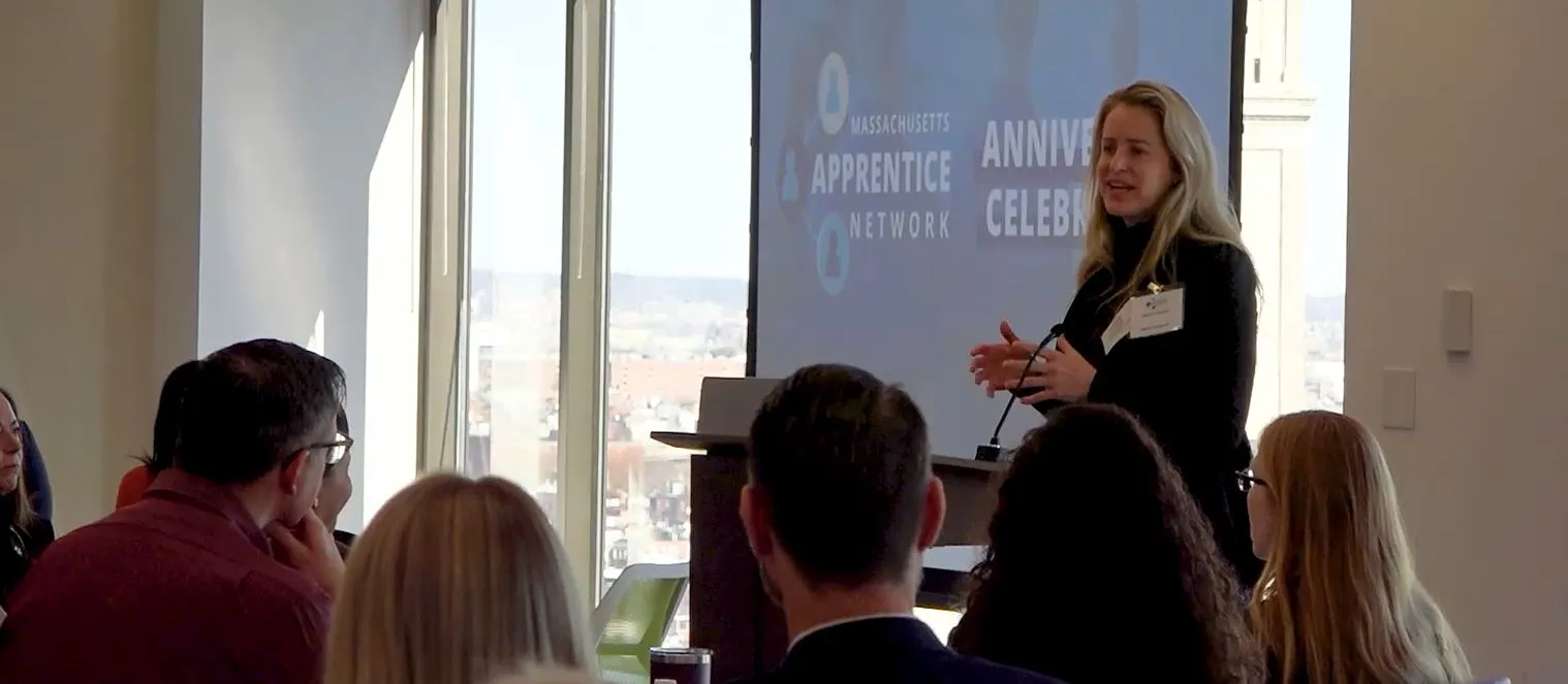 A woman speaks at a podium in front of group of people