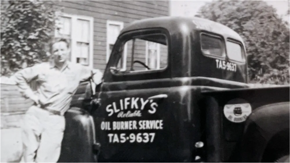 A man standing next to a vintage pickup truck