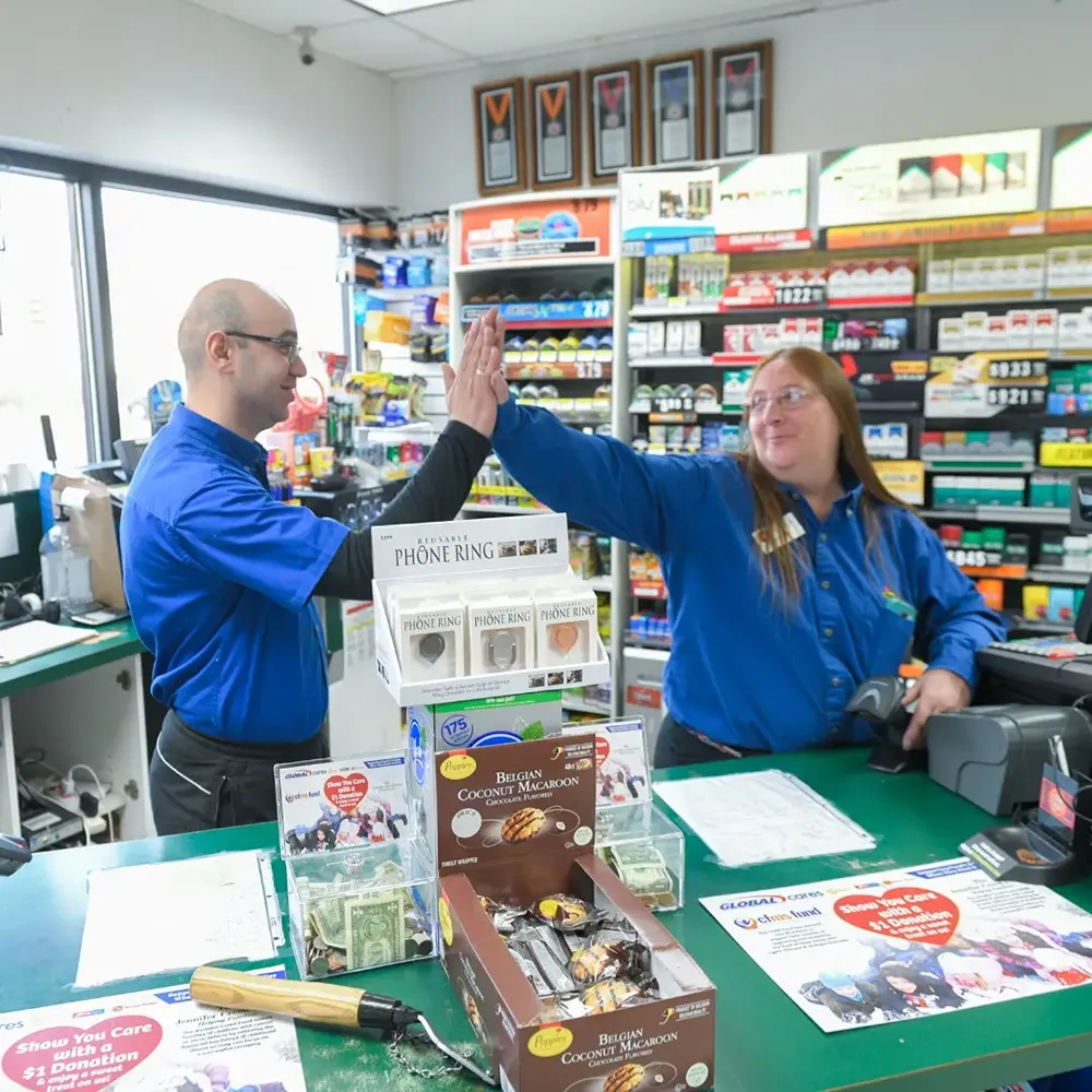 A pair of convience store workers working behind the counter