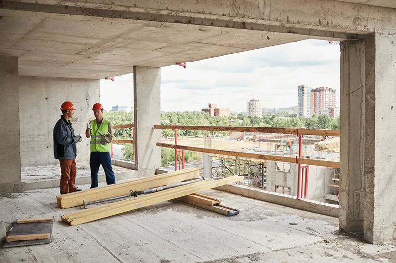 A pair of men having a discusion on a construction site