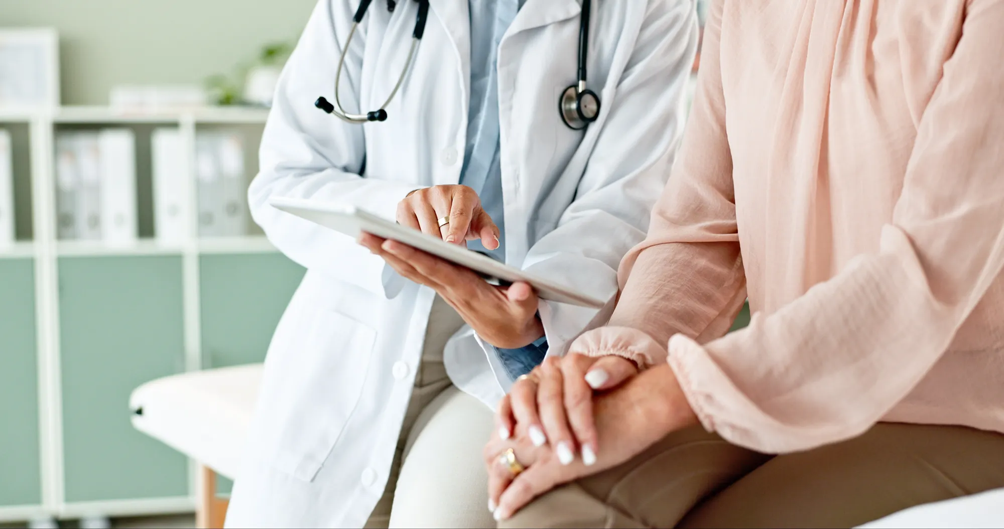 A doctor and patient discuss information on a tablet