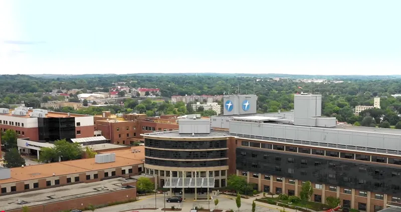 Aerial view of a large hospital campus with multiple buildings and prominent healthcare logos