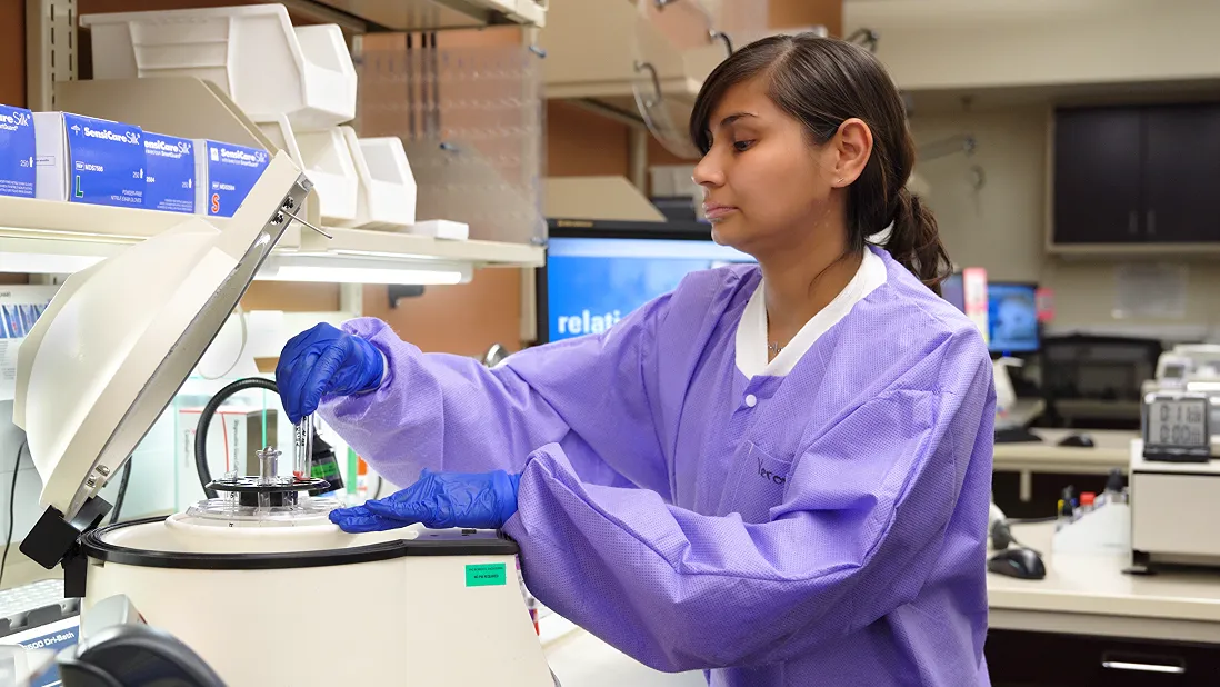 A woman in purple scrubs working in a medical labratory