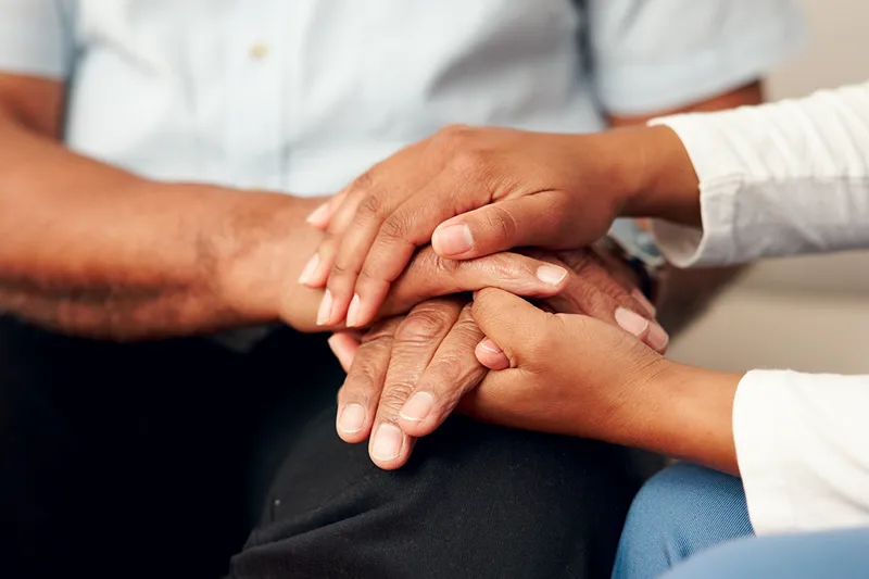 A closeup photo of two people holding hands