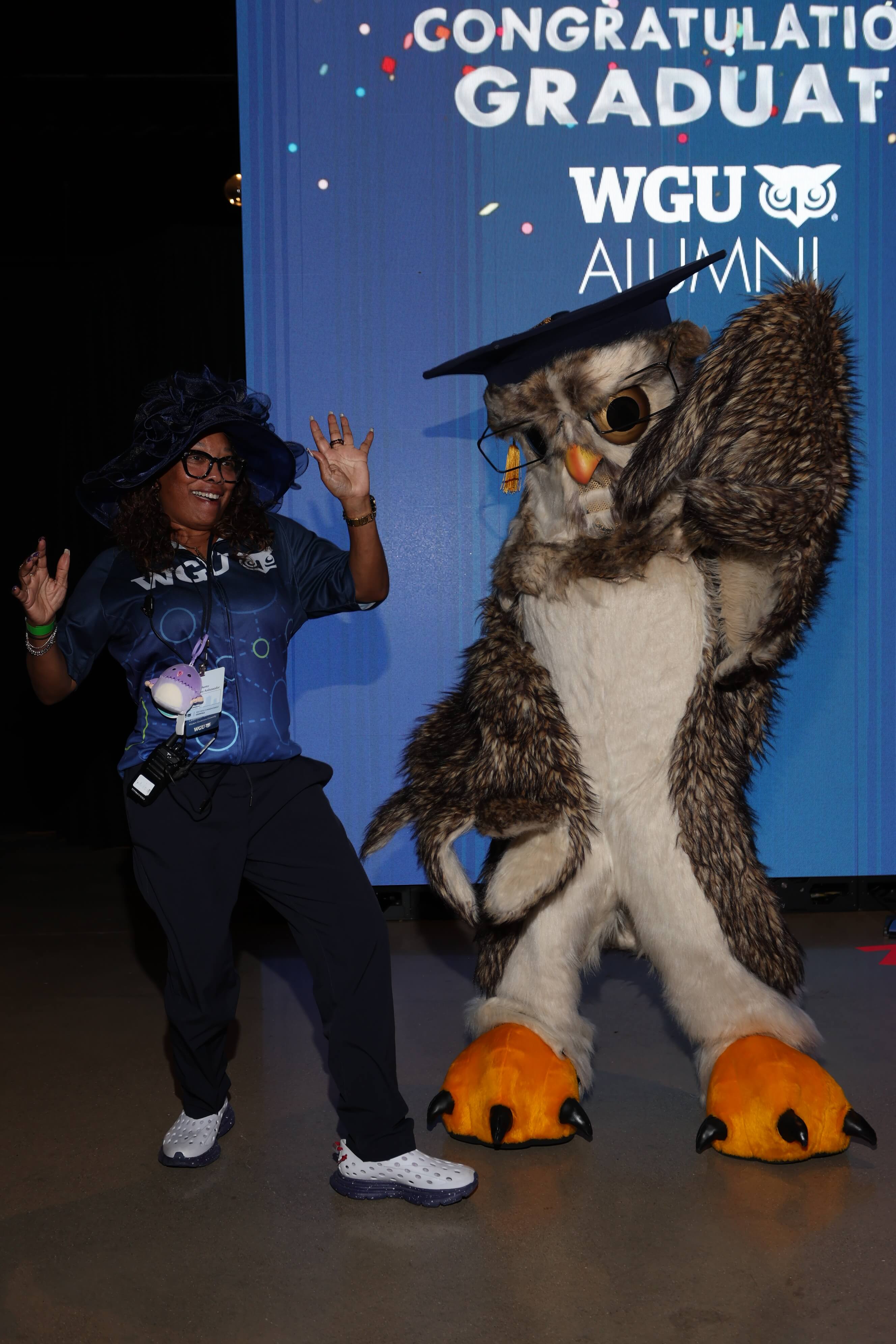 WGU graduate celebrating with the university mascot