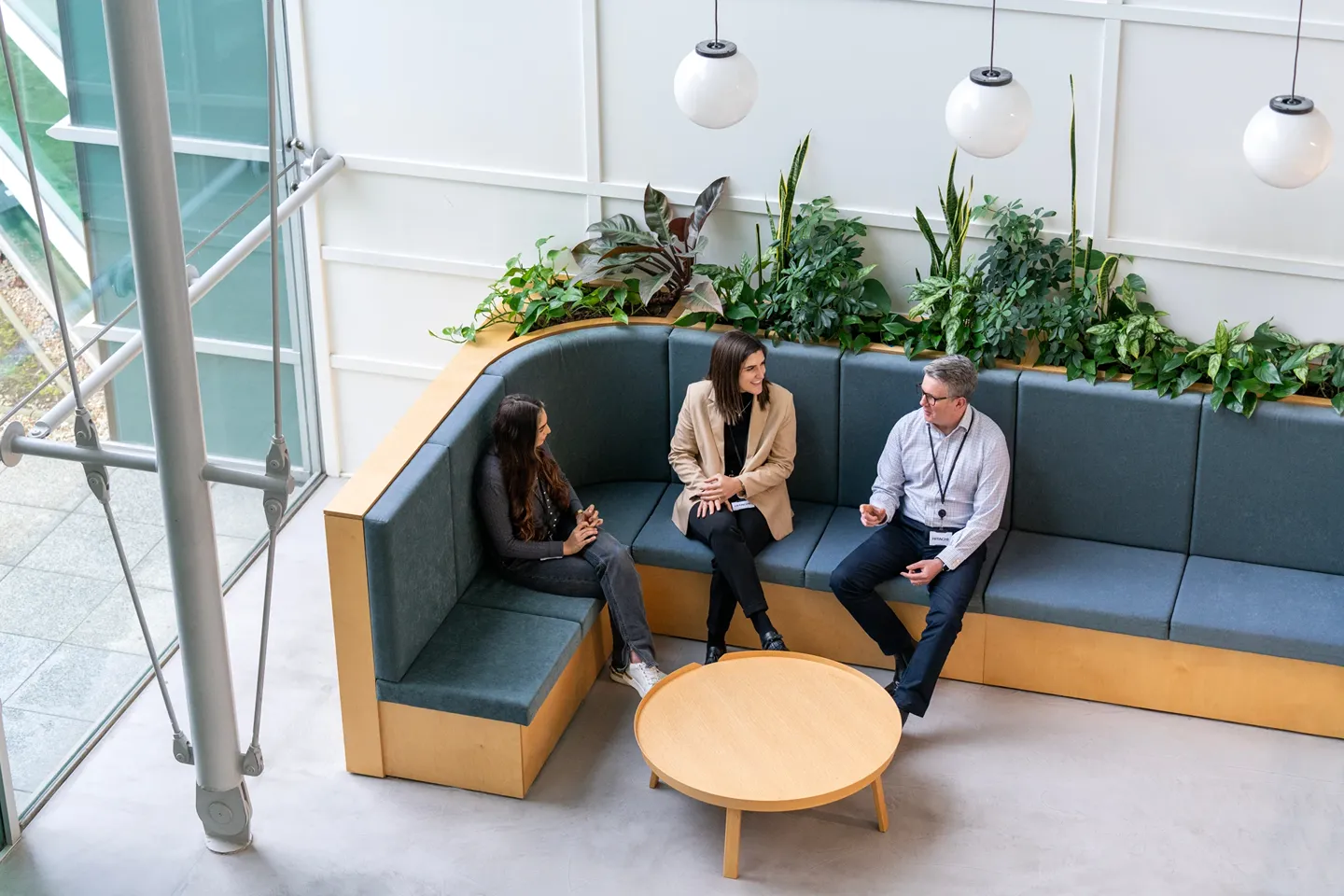 Diverse team of Hitachi employees having a collaborative discussion in a modern office with plants