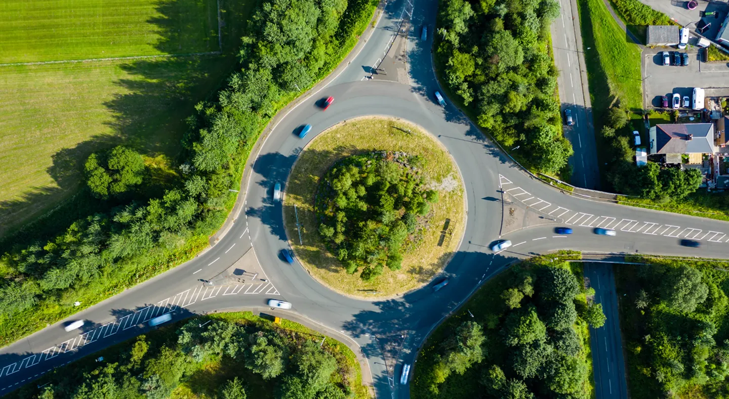 Aerial view of a green roundabout with vehicles representing Hitachi's diverse business sectors