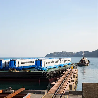 Train traveling along coastal railway representing Hitachi transportation infrastructure