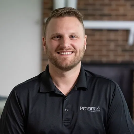 Portrait of a smiling man wearing a black polo shirt with the Progress Residential logo